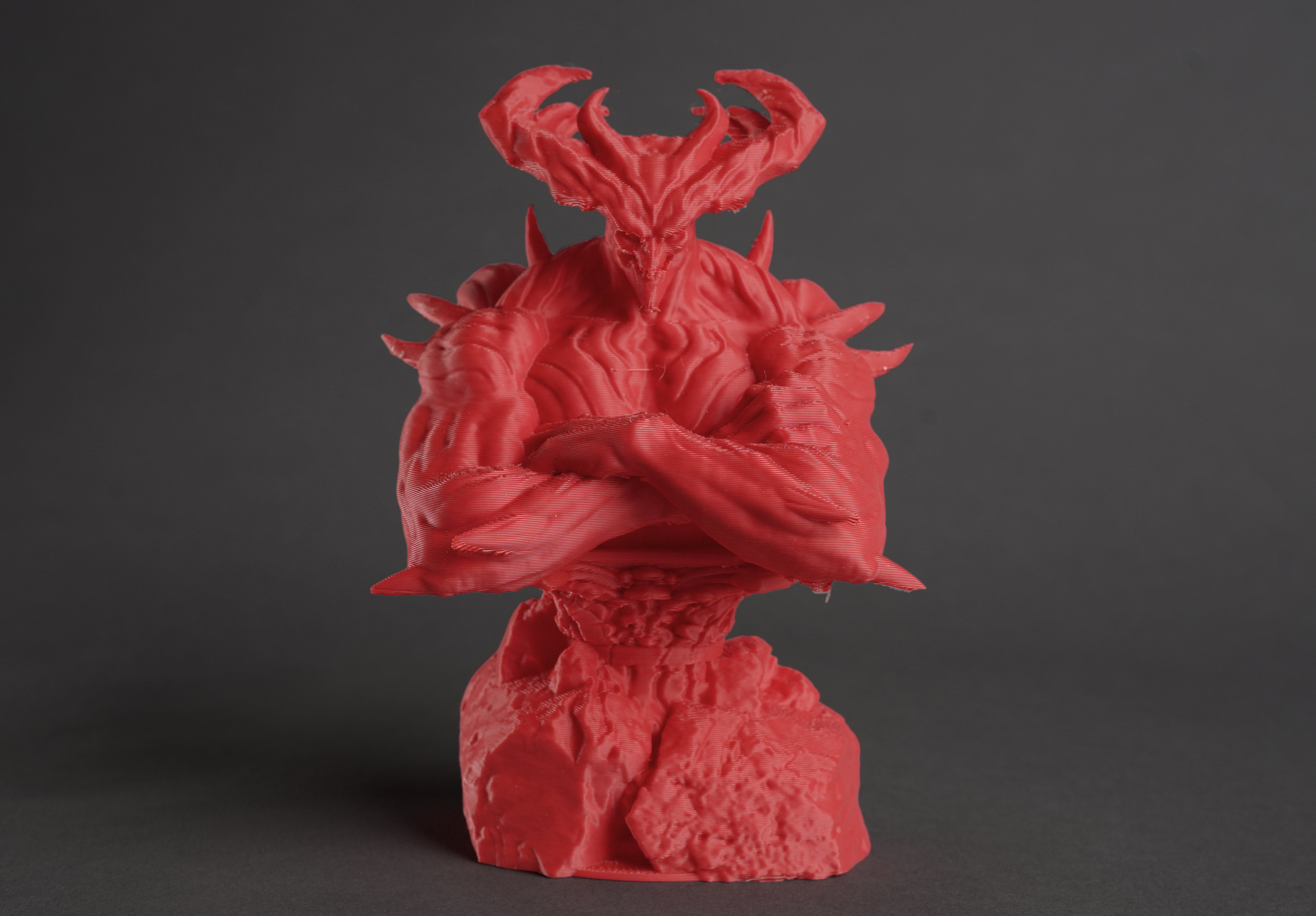 3D printed red demon figure with horns and detailed sculpted features